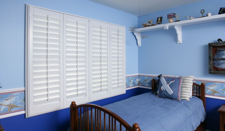 Blue kids bedroom with white plantation shutters in Boise 